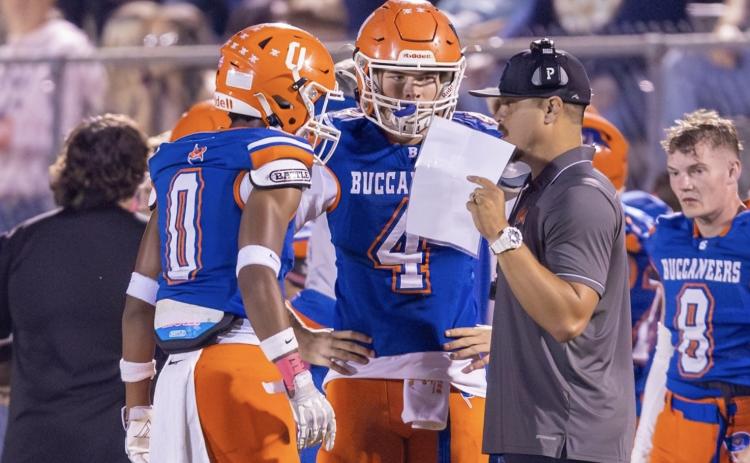 Branford coach Tim Clark (right) speaks to quarterback Trent Land (4) and receiver Maurice Vought (0) during a game this past season. (JACK HOWDESHELL/Lake City Reporter)