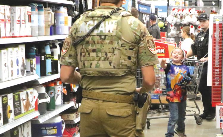 Kenneth Hammett, 7, tries out a new ball and glove in the aisles during last week’s Shop with a Hero event at the Live Oak Walmart. (MORGAN MCMULLEN/Lake City Reporter)