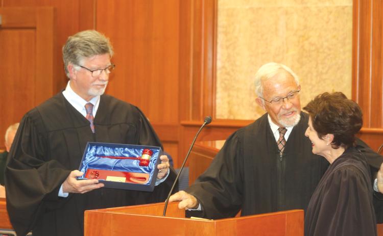 Third Circuit Judge Gregory Parker (from left) and retired Circuit Judge David Fina present retiring Third Circuit Judge Leandra Johnson with a ceremonial gavel during her retirement ceremony Friday. (TONY BRITT/Lake City Reporter)