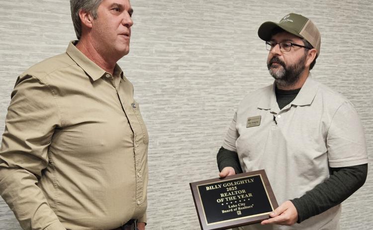 Billy Golightly (right), the broker and co-owner of Lands of North Florida Realty, receives the Lake City Board of Realtors’ Realtor of the Year award Wednesday from Brad Dicks, last year’s winner. (COURTESY)