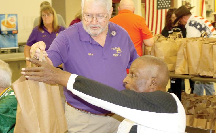 Florida Elks State President Mike Chandler delivers a goodie bag to a veteran at the Robert H. Jenkins VA Domiciliary on Saturday. Chandler was visiting the district Saturday and got to help Lake City Elks Lodge #893 members on the project. (TONY BRITT/Lake City Reporter)
