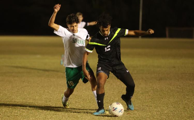 Columbia's Josiah Hopkins tries to maintain possession as Suwannee's Aksel Perez gives chase on Dec. 1. (PAUL BUCHANAN/Lake City Reporter)