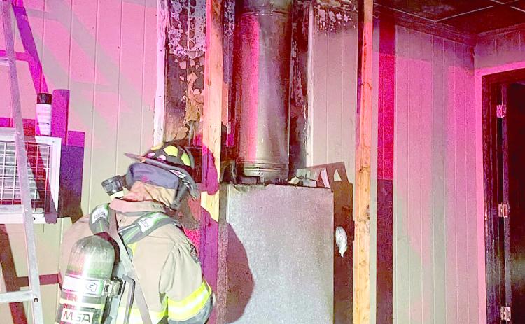 A Lake City firefighter helps extinguish a fire Tuesday night in a house off Siesta Place. The fire, which was found around the chimney for the house’s fireplace, was quickly extinguished and the home was still habitable. (COURTESY LAKE CITY FIRE DEPARTMENT)