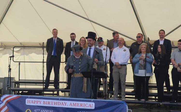 Lake City Mayor Noah Walker and Blue-Grey Army Commanding General Tony Buzzella (center) share a laugh during the opening ceremony of the 47th annual Olustee Festival on the banks of Lake DeSoto at Wilson Park. (TONY BRITT/Lake City Reporter)