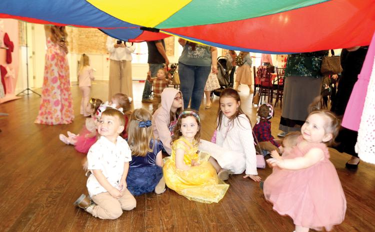 Youngsters attending the Baby Prom at the Blanche Hotel play under a parachute of cloth. (TONY BRITT/Lake City Reporter)