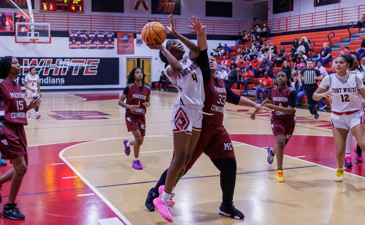 Fort White guard Erickah Roberson fights through a Madison County defender to make the shot during the Region 3-R semifinals on Feb. 13. (JACK HOWDESHELL/Lake City Reporter)