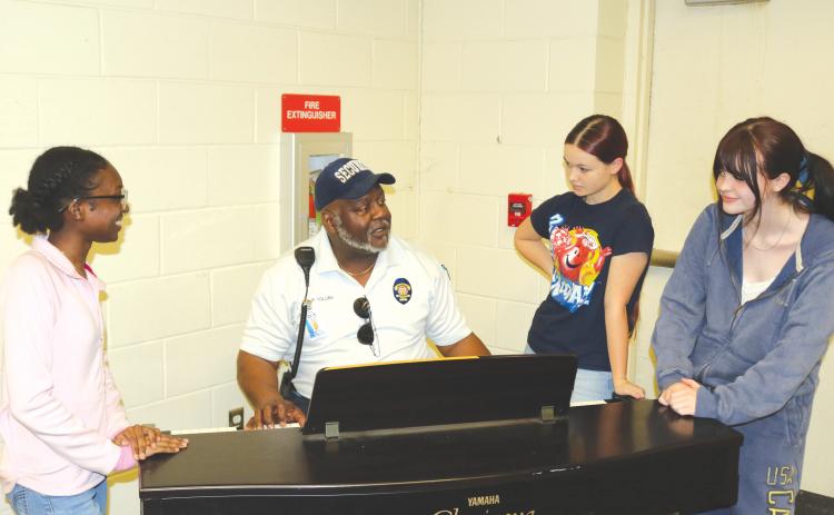 2026 Golden Voice contestant Skye Flournoy (from left) gets musical tips from Ronnie Collins, Golden Voice founder, as Aleah Rogers and Stella Jennings also take in the information. (TONY BRITT/Lake City Reporter)
