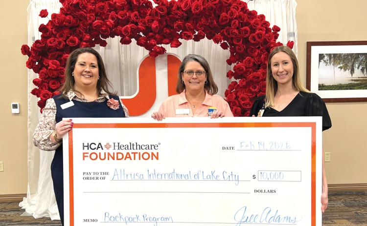 Ginny McCall (left) and Lindsey Covington (right) present a $10,000 check from HCA Florida Lake City Hospital to Sandy Thompson (center) for Altrusa International of Lake City in support of its backpack program, which provides food to local students in need. (COURTESY)