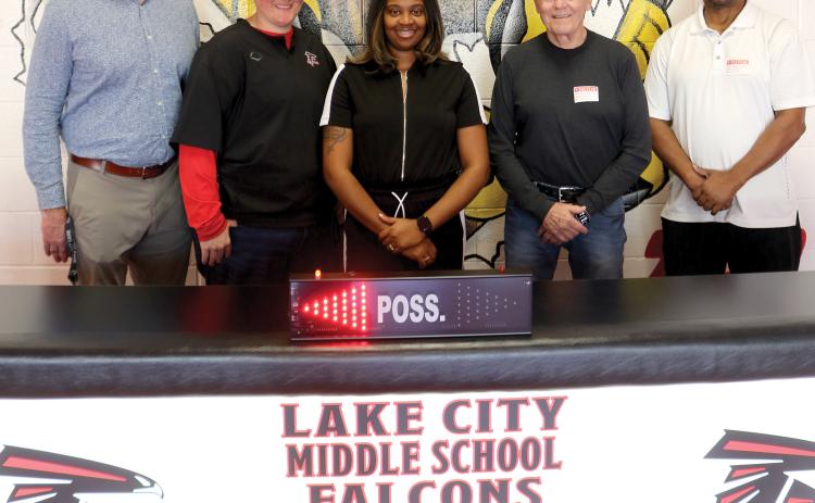 Lake City Middle School officials Dennis Dotson, Brianna Collier and basketball coach Shaniqua Henry, stand with Carl Allison and Wayne Jernigan showing off a new scorer’s table for the school which arrived Tuesday morning. (TONY BRITT/Lake City Reporter)