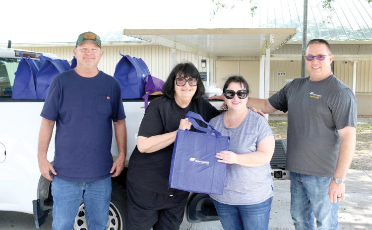 Pat Mundorff (from left) helped out Alice Martin alongside Candi Kish and Todd Martin during the Law family fundraiser. (TONY BRITT/Lake City Reporter)