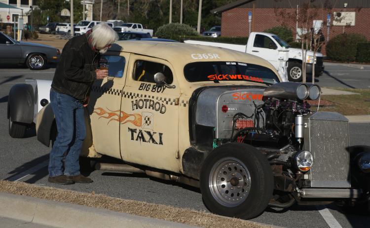 Bob Hubbard checks out the interior of the Hotrod Taxi Monday afternoon as Sick Week participants and observers flocked to Lake City for a pit stop. (MORGAN MCMULLEN/Lake City Reporter)