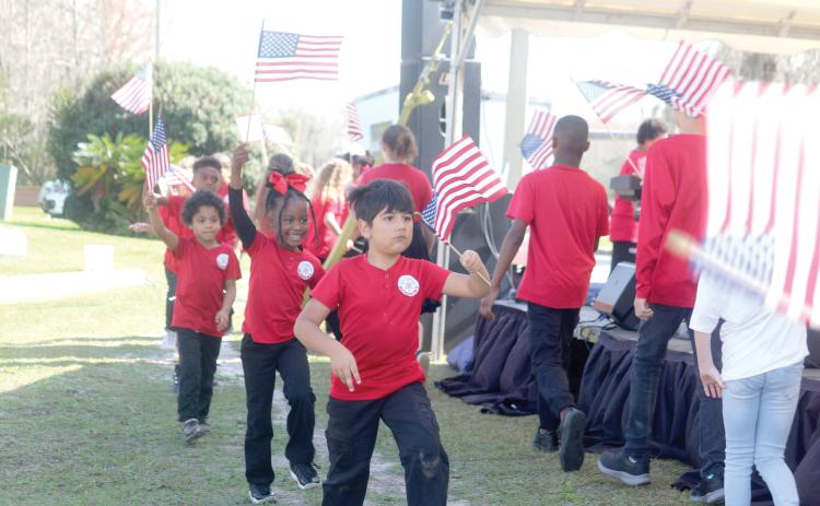 North Florida Arts & Sciences Academy students wave American flags at last year’s Olustee Festival. This year’s festival theme is Celebrate America in honor of the semiquincentennial. (FILE)