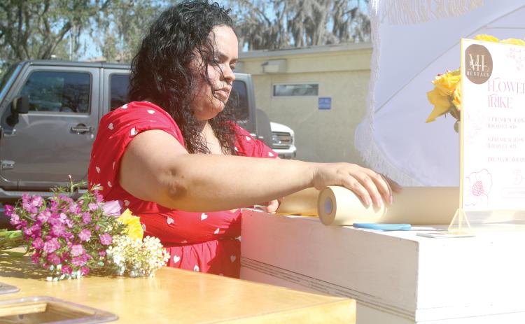 Jesenia Minniefield prepares a bouquet of flowers during last year’s Sweets in the Streets event in downtown Lake City. (FILE)