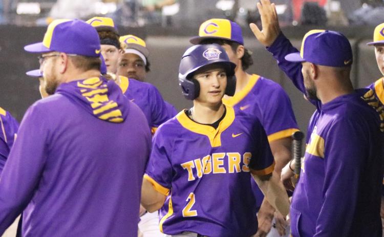 Columbia assistant coach Blake King high fives second baseman Madden Mann in the dugout after Mann scored the go-ahead run against Forest on Wednesday. (JORDAN KROEGER/Lake City Reporter)