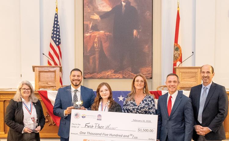 North Florida College student Lillian Clay, of Suwannee County, holds the winning check after winning the inaugural Sunshine State Debate. Florida Commissioner of Education Anastasios Kamoutsas stands to her left, holding the trophy Clay won. (COURTESY NORTH FLORIDA COLLEGE)