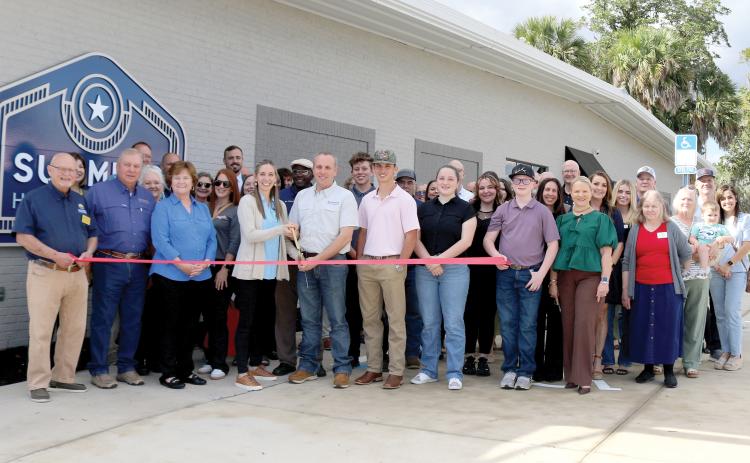 Chris Summers cut the ribbon Thursday during the grand opening celebration for Summers Home Furniture. They were joined by family, friends, employees and members of the Lake City-Columbia County Chamber of Commerce. (TONY BRITT/Lake City Reporter)