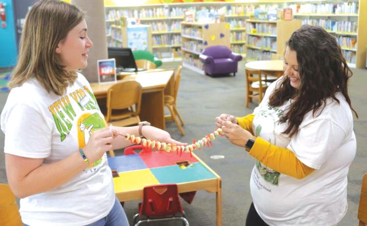 Columbia County Public Library Assistant Director Kate Duong (left) and Andrea Sirard, Columbia County Youth Services librarian, work on creating an edible spinal column made of cereal and candy during a Spring Break program last year. (FILE)
