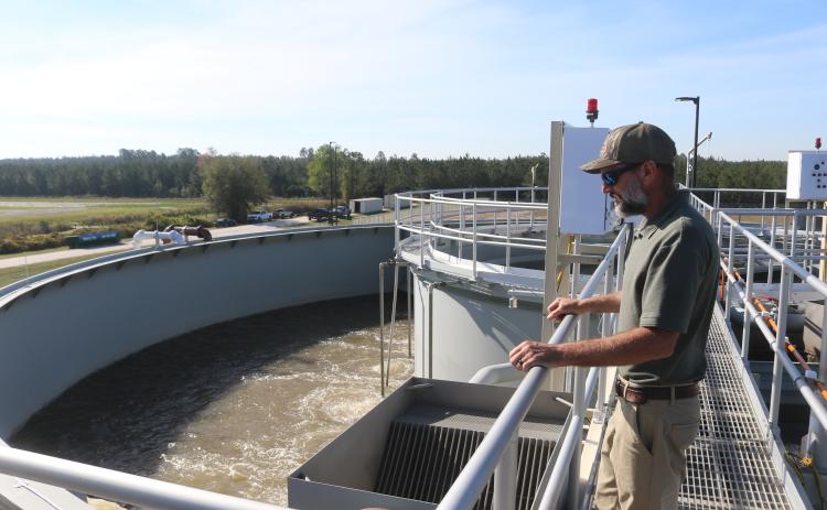 Cody Pridgeon, the City of Lake City’s wastewater director, looks in on a tank of untreated wastewater last year at the North Florida Mega Industrial Park wastewater plant after it began operating. Columbia County’s decision to sell the plant to the city has raised concerns with the North Florida Water Utilities Authority. (FILE)