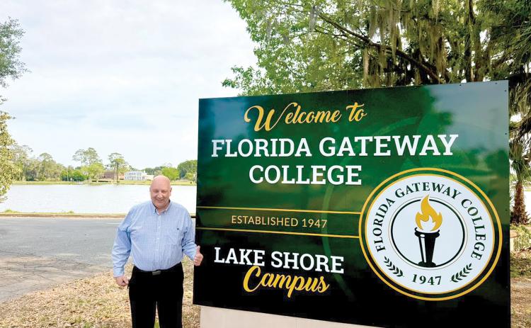 Florida Gateway College President Larry Barrett approves of the college’s new sign for its Lake Shore campus next to the former two-story women’s center building on the banks of Lake DeSoto in downtown Lake City. (COURTESY FLORIDA GATEWAY COLLEGE)