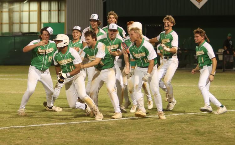 Suwannee shortstop Gabe Garcia (11) celebrates with teammates after hitting a three-RBI walk-off double to beat Columbia 8-7 in extra innings on Thursday. (PAUL BUCHANAN/Lake City Reporter)