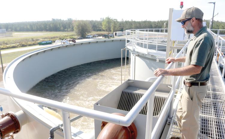 Cody Pridgeon, City of Lake City wastewater director, looks in on a tank of untreated wastewater at the North Florida Mega Industrial Park wastewater treatment plant last March shortly after it began operating. (FILE)