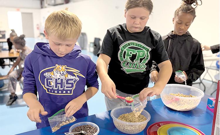 Third grade students at Niblack Elementary practice measuring by making their own trail mix through the nutrition lessons taught by UF/IFAS Extension Columbia County during PE classes at the school. (COURTESY UF/IFAS EXTENSION COLUMBIA COUNTY)