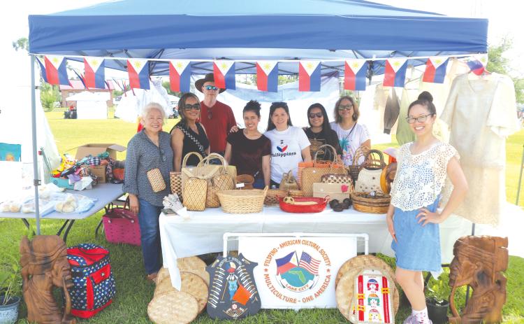 Members of the Filipino-American Cultural Society pose in their booth at last year’s Multi-Culutural Spring Market Festival near Darby Pavilion at Wilson Park. (FILE)