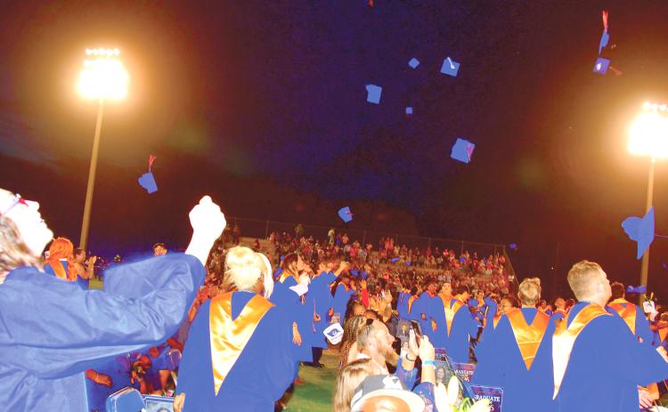 Branford High graduates toss their caps into the air after graduating during Friday’s commencement ceremony. (ROB WOLFE/Lake City Reporter)