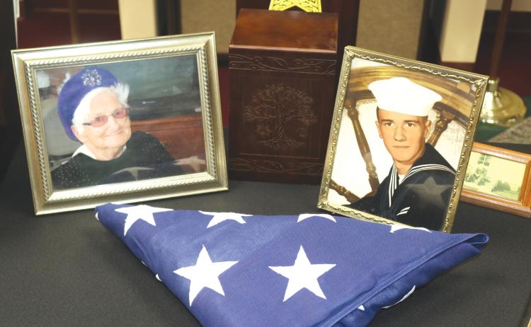 Photos of Lonnie Reeves (right) and Virginia Reeves sit alongside a trifold American flag during Wednesday morning’s Columbia County Sheriff’s Office press conference. (TONY BRITT/Lake City Reporter)