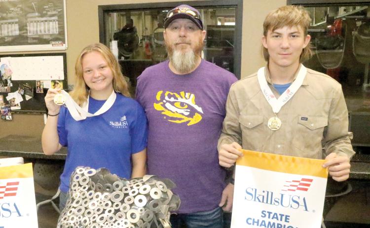 Columbia High School welding students Ruby Chandler (left) and Mason Dusen (right) are competing at the national SkillsUSA competition in Atlanta next week. They are joined by CHS welding instructor Darryl Thomas. (TONY BRITT/Lake City Reporter)