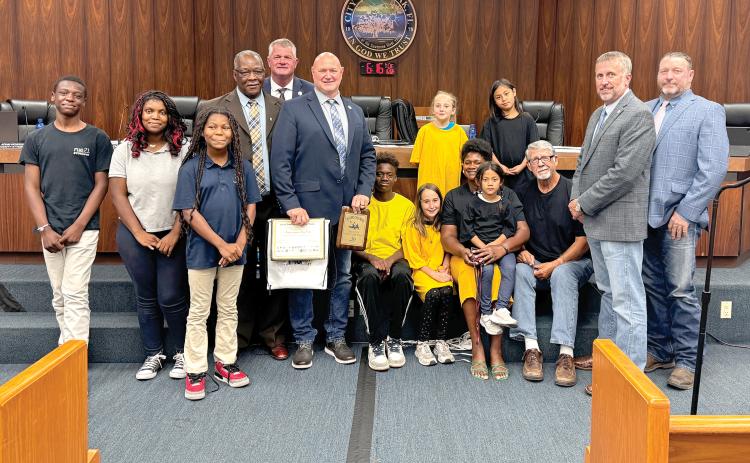 The Suwannee County Commission is pictured with Our Community Cares Coalition officials Bo Beauchemin and Befaithful Coker as well as children in the program. (JAMIE WACHTER/Lake City Reporter)