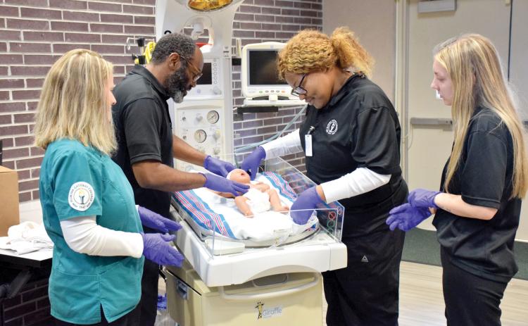 Nursing students at Florida Gateway College check on a doll who is on a radiant warmer donated to the school by the Lake Shore Hospital Authority. (COURTESY FLORIDA GATEWAY COLLEGE)