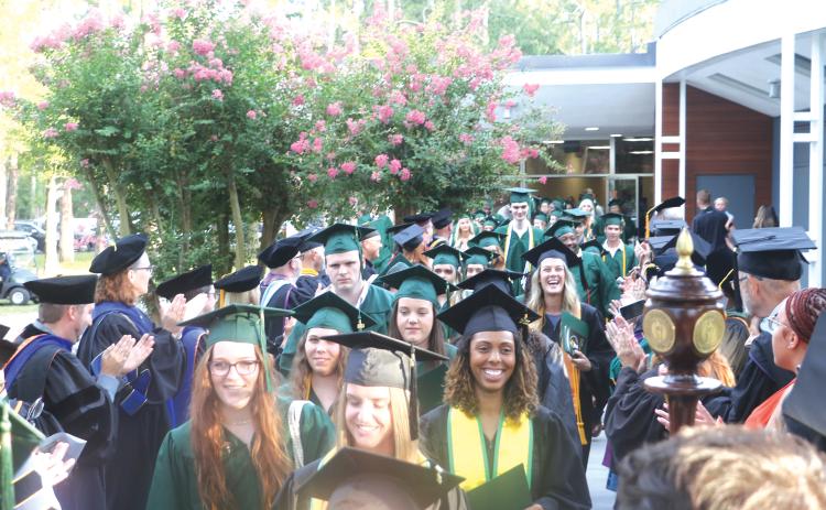 Florida Gateway College graduates file out of the Howard Center through columns of FGC  faculty and staff following a prior year’s graduation ceremony. (FILE)
