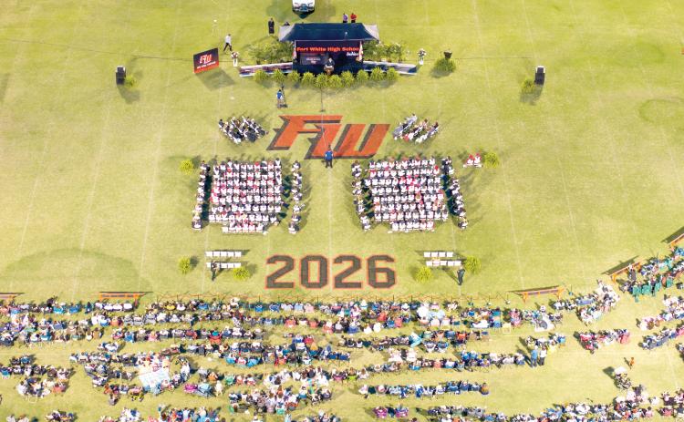 Family and friends surround the graduates on the field at Arrowhead Stadium on Friday night as Fort White High held its commencement ceremony for the Class of 2026. The ceremony was interrupted for about 45 minutes due to lightning in the area. (RAY CARPENTER/Lake City Reporter)