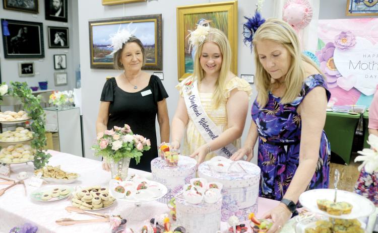 Karen Thurston (from left), Laney Grinstead and Laura Hunter Null, prepare snacks for women attending the ‘Hats Off To Mom’ fundraiser on Saturday at the Gateway Art Gallery. (TONY BRITT/Lake City Reporter)