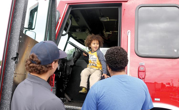 Kiler Simmons, 2, is excited about getting behind the steering wheel of a Lake City firetruck during the Kiwanis Kids Day on Saturday at the Florida Gateway Fairgrounds. (TONY BRITT/Lake City Reporter)