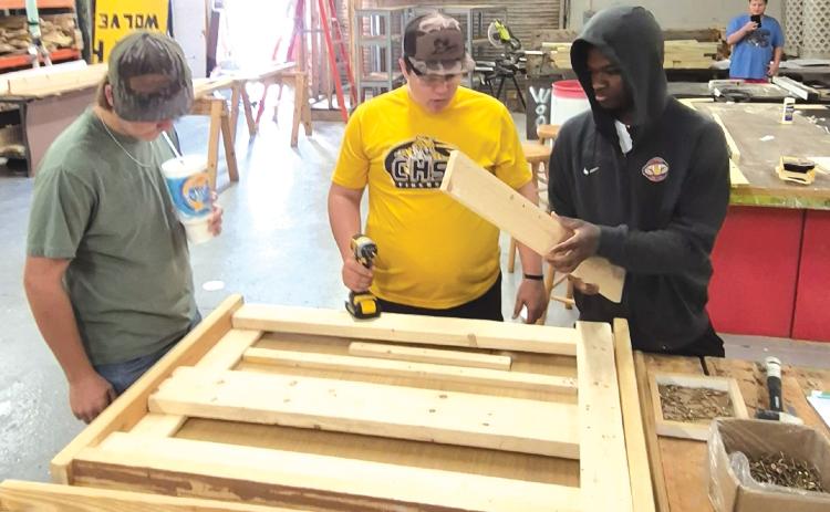Mason Carrol (from left), Ashton Ambrose and Jordaeton Youmans work on making one of the beds for the local chapter of Sleep in Heavenly Peace. (COURTESY)