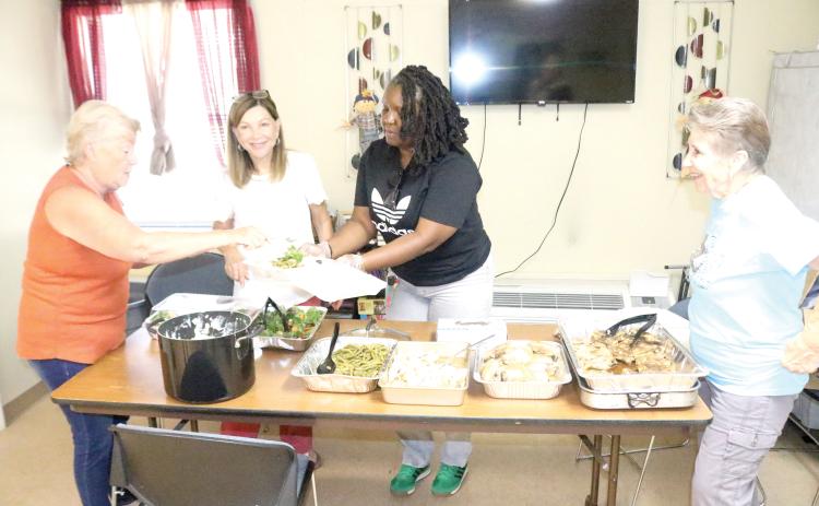 Trish Webb (from left), Roseanna Lee, Tanzania Williams and Bonnie Page prepare to-go plates for veterans who reside in the Lake City Cabins for Veterans on Friday afternoon. The Columbia County Executive Committee provides the lunches, free, on the last Friday of every month. (TONY BRITT/Lake City Reporter)