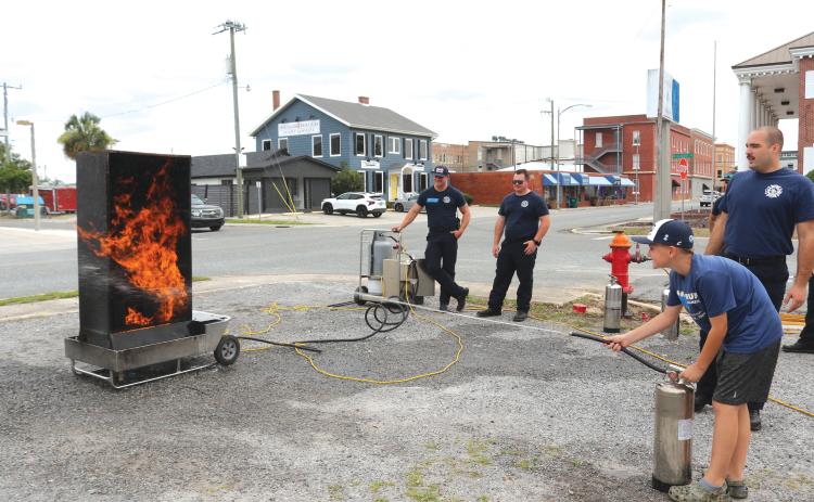 Easton Starling, 11, utilizes training he learned at a Lake City Fire Department summer camp to douse flames with a fire extinguisher. (TONY BRITT/Lake City Reporter)