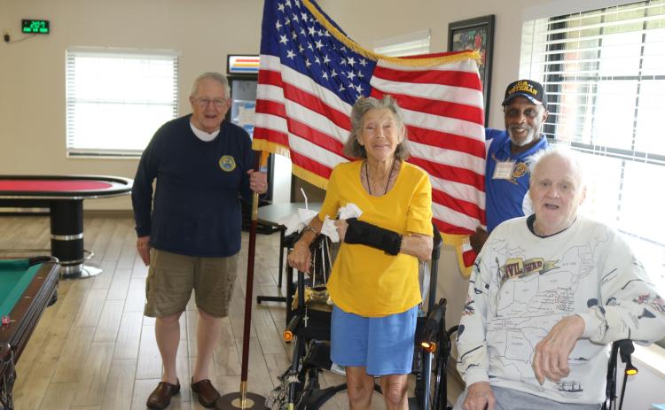 U.S. Army veterans John “Dutch” Shultz (foreground from left), Dawn Huston and Terry Holliday pose for a Flag Day photograph as  Kenneth Burkes, an American Legion member, holds the flag. (TONY BRITT/Lake City Reporter)