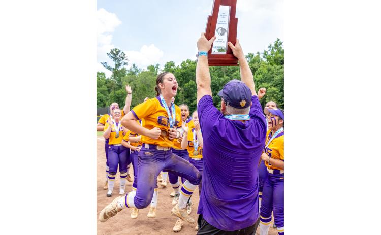 Columbia shortstop Alannah Lord (left) celebrates as coach Joe Saucier (right) hoists the Class 4A state championship trophy after the Tigers defeated Lake Wales for the title on May 23. (JACK HOWDESHELL/Lake City Reporter)