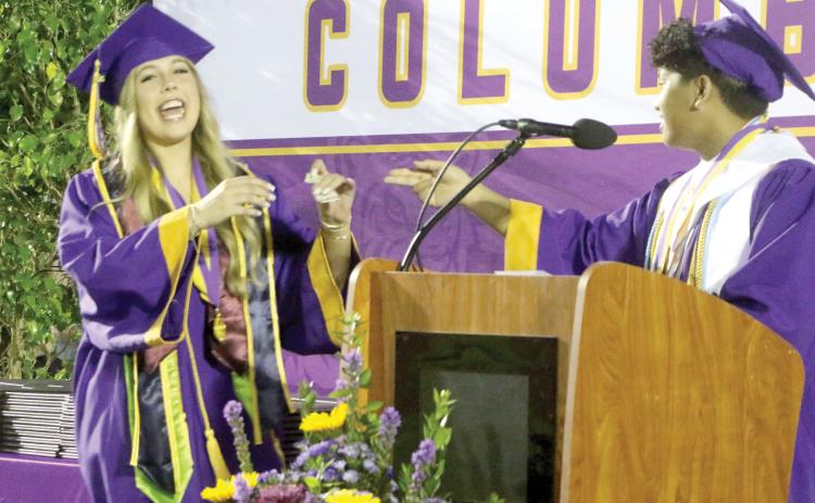 CHS Class of 2026 valedictorian Nathan Chiong (right) pays off his four-year-long $5 bet with Kadence Bates-Rogers during Friday’s commencement ceremony. (MORGAN MCMULLEN/Lake City Reporter)