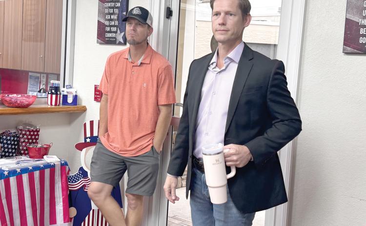 Adam Collins (right) listens as the results were delivered Tuesday night in the Live Oak District 1 runoff election. Collins won the election. (JAMIE WACHTER/Lake City Reporter)