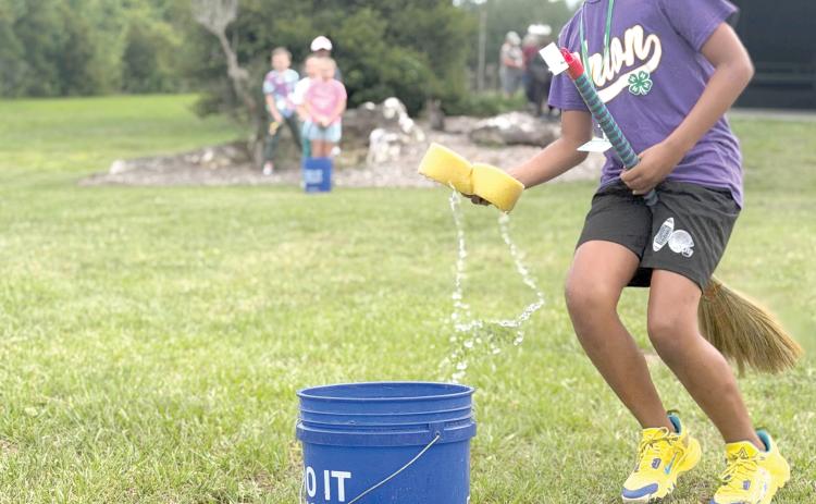 Zayden Jones learns the art of broom handling while participating in a relay race during Columbia County 4-H’s School of Life Skills for Magical Beings camp earlier this month. (COURTESY)