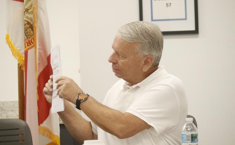 North Florida Water Utilities Authority Attorney Grady Williams holds up one of the agreements that established the NFWUA during Monday’s meeting. Williams and Executive Director Shannon Roberts asked the board for direction as far as to the timeline for transferring assets from Columbia and Suwannee counties to the Authority. (JAMIE WACHTER/Lake City Reporter)