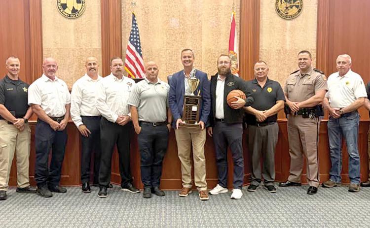 Columbia County Clerk of Court Jay Swisher holds the Boots and Badges championship trophy ahead of this year’s tournament. The Legal Eagles, representing attorneys at the courthouse, are the defending champions. (COURTESY)