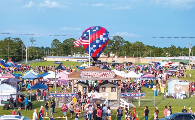 A hot air balloon stands ready behind an American flag as part of the 250th anniversary celebration of the United States of America on Saturday at the Florida Gateway Fairgrounds. The hot air balloons, though, were unable to fly due to windy conditions. The celebration attracted more than 7,000 to the fairgrounds. (RAY CARPENTER/Lake City Reporter)