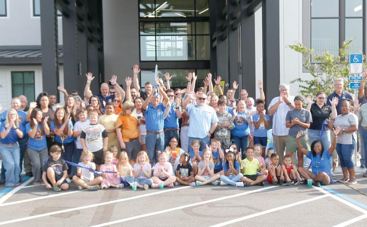Columbia County School Board member Keith Hudson holds up the scissors after cutting the ribbon to open up the new Eastside Elementary School on Tuesday morning. Hudson is joined by students, faculty and staff at Eastside as well as school district officials and members of the Gilbane Construction company that built the new school. (JAMIE WACHTER/Lake City Reporter)
