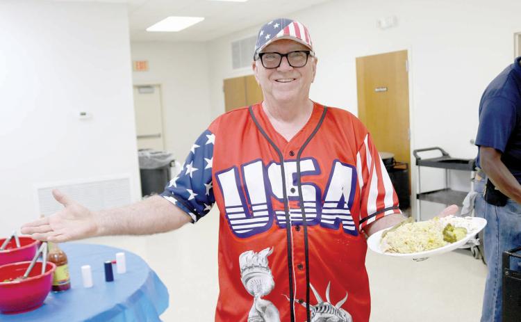 Layne Schultetus, clad in an American jersey, was all smiles with a plate full of the chicken perlau dinner ahead of Thursday’s Columbia County GOP candidate rally at the Westside Community Center. (TONY BRITT/Lake City Reporter)