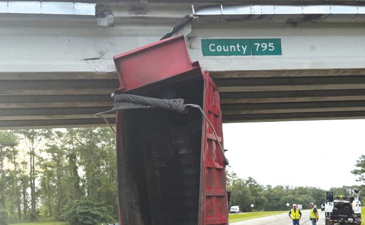 A dump truck’s bed sits in the eastbound lanes of Interstate 10 after hitting the County Road 795 overpass on Monday. (COURTESY FHP)